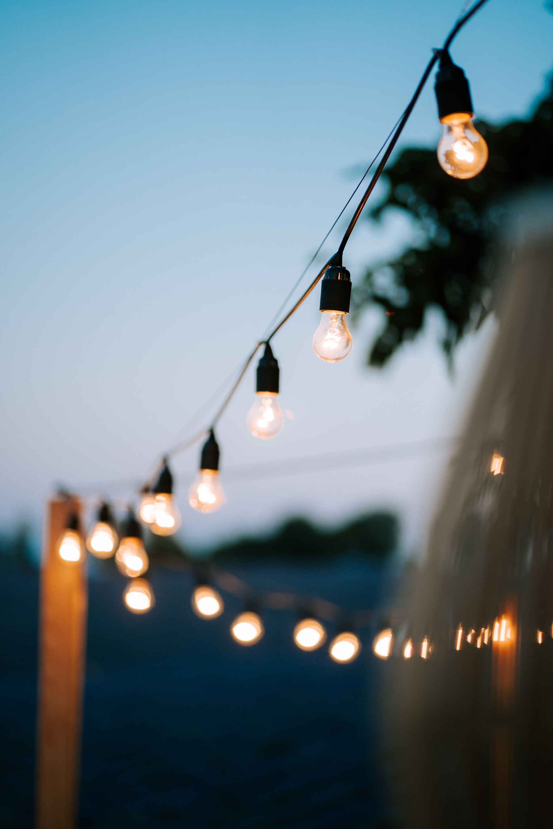 Twinkling outdoor lights illuminate a serene evening setting at dusk